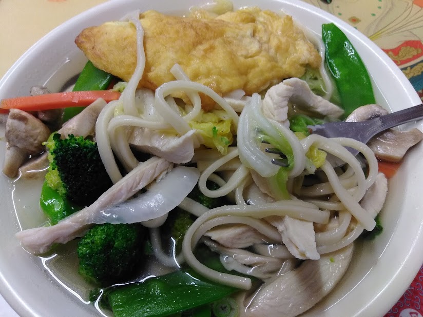 Chicken noodle soup with vegetables and an egg roll
